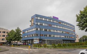 Exterior view of an office building at Maanlander 47 in Amersfoort Calveen, suitable for office space rental. A modern, blue façade with multiple windows.
