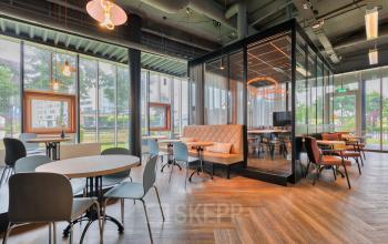 Modern furnished office space for rent at Maanlander 47 in Amersfoort Calveen, featuring elegant seating areas with large windows and contemporary lighting.