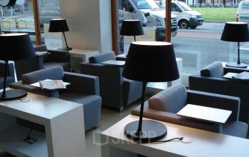 Modern lounge area at office space rental at Piet Mondriaanplein 13-31, Amersfoort Centraal Station, with stylish seating and lamps.