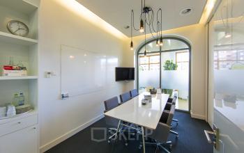 Modern office space rental at Piet Mondriaanplein 13-31, Amersfoort Centraal Station with a meeting table, whiteboard, and television.