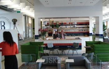 Professionals engaged in a business meeting in a modern lounge area at office space rental at Piet Mondriaanplein 13-31, Amersfoort Centraal Station.