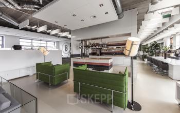 Modern open floorplan office space rental at Piet Mondriaanplein 13-31, Amersfoort Centraal Station with stylish seating and ample natural light.