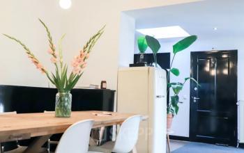 Furnished office space featuring a wooden table with white chairs and stylish decor at Utrechtseweg 129, Amersfoort Centraal Station.
