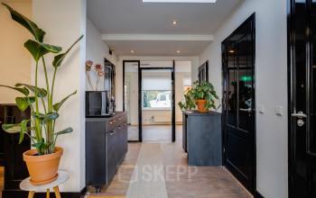 Bright office interior with black doors, plants, and a skylight at Utrechtseweg 129, ideal for office space rental in Amersfoort Centraal Station.