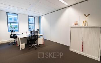 Office space rental at Smallepad 32, Amersfoort Centraal Station. Modern workspace with desks, chairs, and a cabinet.