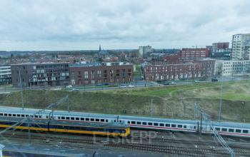 Amersfoort Centraal Station neighborhood view from Smallepad 32 office building, including train tracks and residential buildings.