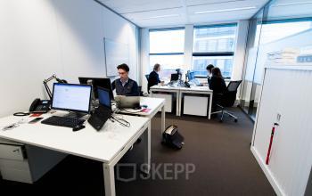 Modern furnished office space rental at Smallepad 32, Amersfoort Centraal Station, with professionals working at desks with computers.
