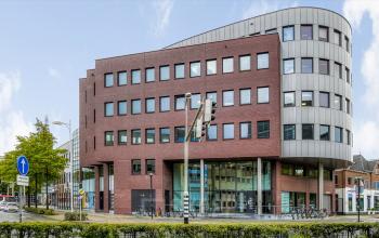 Exterior view of a modern office building at Van Asch van Wijckstraat 2-4, Amersfoort Centrum. Ideal location for office space rental, showcasing a blend of contemporary architecture and functionality in a bustling urban setting.