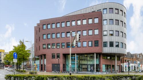 Exterior view of a modern office building at Van Asch van Wijckstraat 2-4, Amersfoort Centrum. Ideal location for office space rental, showcasing a blend of contemporary architecture and functionality in a bustling urban setting.