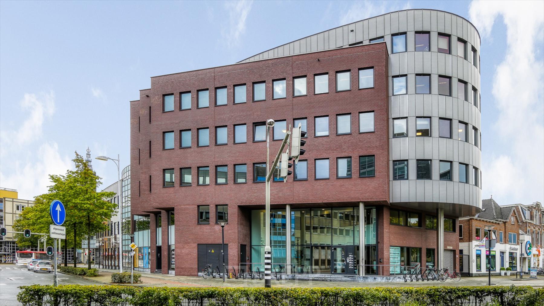Exterior view of a modern office building at Van Asch van Wijckstraat 2-4, Amersfoort Centrum. Ideal location for office space rental, showcasing a blend of contemporary architecture and functionality in a bustling urban setting.
