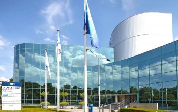 Exterior view of the modern office building at Stadsring 201, featuring reflective glass windows and flagpoles, suitable for office space rental in Amersfoort Centrum.