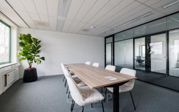 Bright office space at Stadsring 201 featuring a long table with chairs, ideal for meetings. Large windows illuminate the room, making it a perfect office space rental in Amersfoort Centrum.