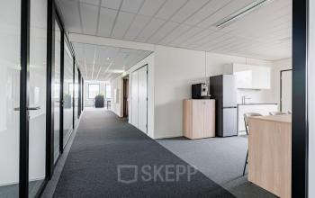 Bright office space at Stadsring 201, Amersfoort Centrum, featuring a modern layout with glass partitions and a kitchenette. Ideal for businesses seeking office space rental.