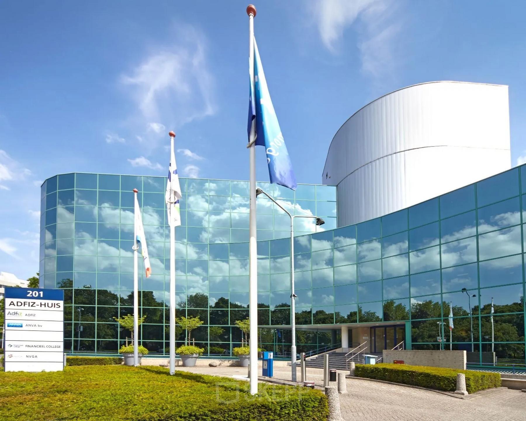 Exterior view of the modern office building at Stadsring 201, featuring reflective glass windows and flagpoles, suitable for office space rental in Amersfoort Centrum.