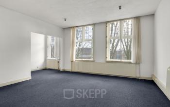 Bright office space with large windows and carpeted floors, ideal for rent in Stadsring 248-250, Amersfoort Centrum. Natural light enhances the clean, open layout, perfect for professional use.