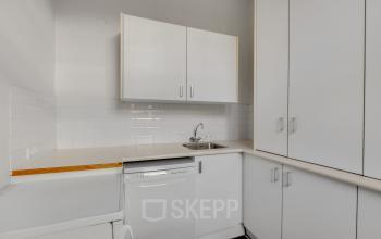 Compact office kitchenette at Stadsring 248-250, Amersfoort Centrum featuring white cabinets and a dishwasher. Ideal for office space rental with essential amenities.