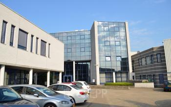 Exterior view of office space rental at Algolweg 9-11, featuring a modern facade with large windows and an adjacent parking area in Amersfoort De Hoef.