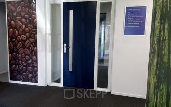 Office entrance at Algolweg 9-11, Amersfoort De Hoef, featuring a blue door and decorative wall panels, ideal for office space rental.