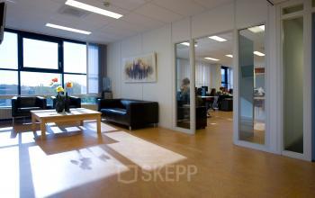 Bright office space in Amersfoort De Hoef at Algolweg 9-11 with modern furnishings, featuring desks, chairs, and a coffee table. Ideal for office space rental.