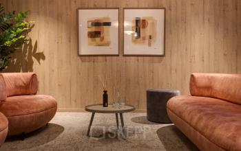 A cozy lounge space featuring round couches, abstract artwork, and a central coffee table, ideal for informal meetings and relaxation at Vanadiumweg 11, Amersfoort Isselt. A perfect spot for office space rental.