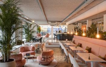 Modern office space for rent at Vanadiumweg 11, Amersfoort Isselt featuring stylish furnishing with comfortable seating, ambient lighting, and greenery enhancing a productive work environment.