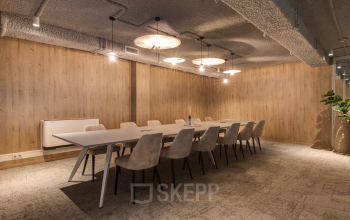 Spacious and stylish conference room at Vanadiumweg 11, Amersfoort Isselt, perfect for office space rental. Features modern lighting and a large table with comfortable seating, ideal for meetings.