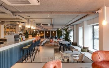 Spacious and modern common area at Vanadiumweg 11 in Amersfoort Isselt, featuring stylish seating and a bar area perfect for casual meetings and networking, ideal for office space rental needs.