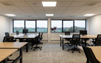 Bright office space at Vanadiumweg 11, Amersfoort Isselt with multiple desks, ergonomic chairs, and large windows offering scenic views. Ideal for office space rental.
