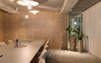 Elegant conference room at Vanadiumweg 11, Amersfoort Isselt, featuring a large table, stylish lighting, and modern decor. Perfect setting for business meetings and office space rental opportunities.