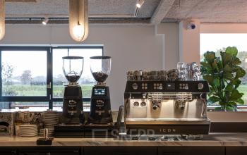 Modern office pantry with coffee machines and fridge at Vanadiumweg 11, Amersfoort Isselt, ideal for office space rental.