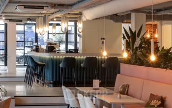 Modern office interior at Vanadiumweg 11, Amersfoort, featuring stylish furnishings, ambient lighting, and a cozy lounge area for collaborative work and relaxation. Ideal for office space rental with a chic atmosphere.