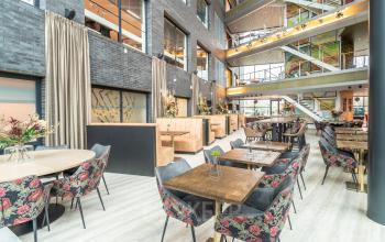 Modern and inviting office space rental at Prof. W.H. Keesomlaan 12, Amstelveen, featuring stylish seating areas, tables, and a well-lit atmosphere perfect for collaboration.