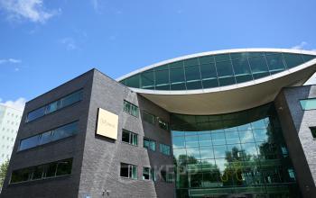 Exterior view of office building located at Prof. W.H. Keesomlaan 12, Amstelveen, with large glass windows and modern architecture, showcasing a professional space for office space rental.
