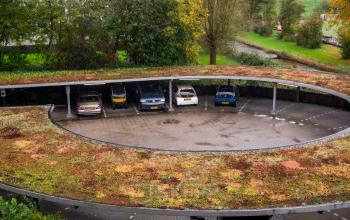 Exterior view of the parking lot at Prof. W.H. Keesomlaan 12 in Amstelveen, featuring a rooftop garden above the parking spaces.