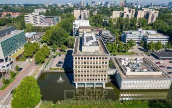 Aerial view of office building at Professor E.M. Meijerslaan 1, Amstelveen, surrounded by water and greenery, ideal for office space rental with easy access to city amenities.