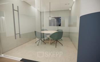 Modern, glass-enclosed conference room with a round table and four chairs available for office space rental at Professor E.M. Meijerslaan 1 in Amstelveen.