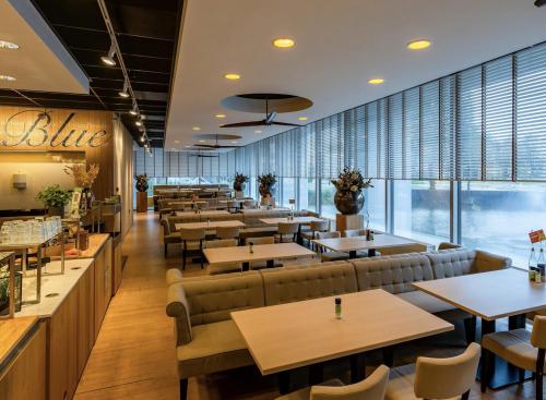 Modern dining area in an office building at Professor E.M. Meijerslaan 1, Amstelveen, featuring well-arranged tables and natural lighting, ideal for casual meetings or breaks. Explore available office space rental options.