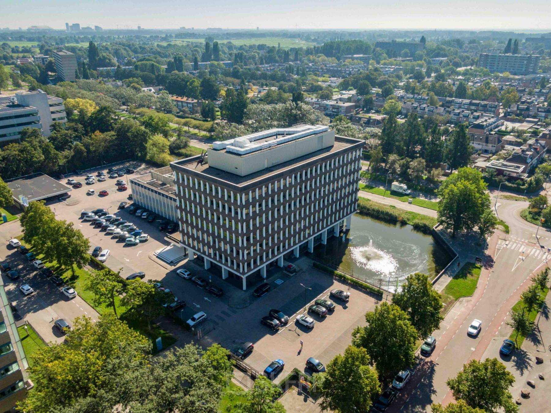 Aerial view of office building at Professor E.M. Meijerslaan 1, Amstelveen, featuring ample parking and scenic surroundings. Ideal for those seeking office space rental in a well-connected location.