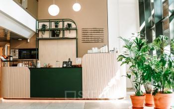 A stylish office at Stroombaan 4, Amstelveen, featuring a welcoming reception with a counter, plants, and modern decor—ideal for office space rental.