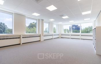 Unfurnished, well-lit office space at De Gondel 1, Amstelveen, showcasing large windows with a view, available for rent.