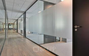 Modern hallway at office space rental in Amstelveen with glass doors and light wood flooring at De Gondel 1.