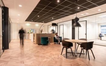 Modern office space available for rent at H.J.E. Wenckebachweg 123 in Amsterdam Amstel Business Park, featuring stylish seating areas and workspaces with a contemporary design.
