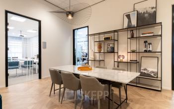 Modern meeting area in an office located at H.J.E. Wenckebachweg 123, Amsterdam Amstel Business Park; featuring a marble table, chic chairs, and stylish decor.