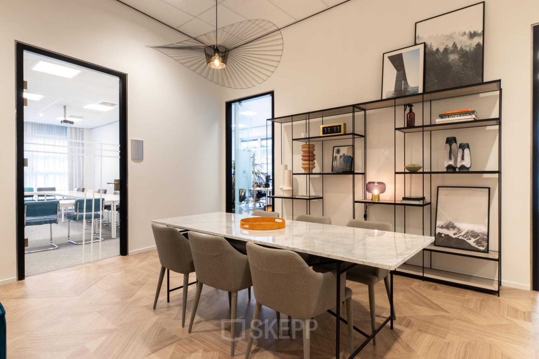 Modern meeting area in an office located at H.J.E. Wenckebachweg 123, Amsterdam Amstel Business Park; featuring a marble table, chic chairs, and stylish decor.