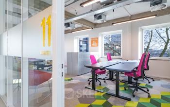 Bright workspace with modern furniture at Willem Fenengastraat 2, Amsterdam Amstel Business Park. Features colorful chairs and geometric carpet tiles.