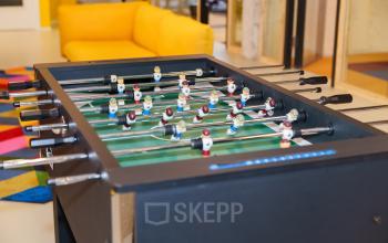 Colorful lounge area with a foosball table and a yellow sofa at Willem Fenengastraat 2 in Amsterdam Amstel Business Park, ideal for office space rental.