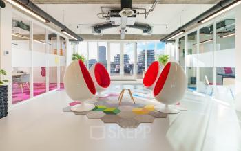 Modern workspaces at Willem Fenengastraat 2 in Amsterdam Amstel Business Park, featuring vibrant seating and bright interiors with large windows.