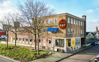 Exterior view of the office building at Willem Fenengastraat 2, Amsterdam Amstel Business Park, with some bicycles parked outside.