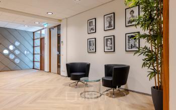 Inviting office lounge at Joan Muyskenweg 82 in Amsterdam Amstel Business Park, featuring sleek black chairs and a glass table, perfect for casual meetings or breaks.