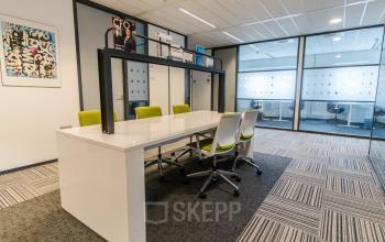 Modern office space rental at Joop Geesinkweg 901-999, Amsterdam Amstel Business Park, featuring a well-lit meeting area with stylish furnishings.